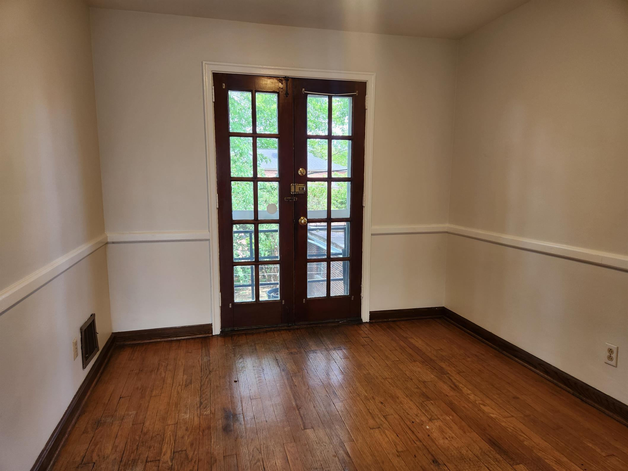 Bright dining room featuring hardwood flooring and glass back doors letting in natural light.